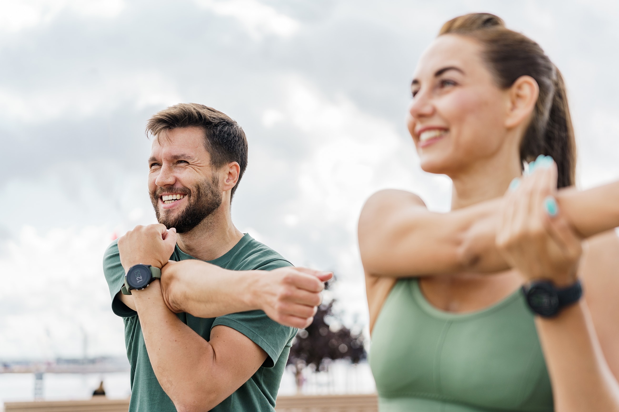 Outdoor stretching session with smiling individuals.